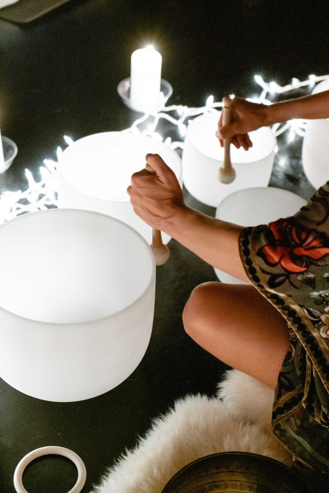 Hands gently resting on crystal singing bowls