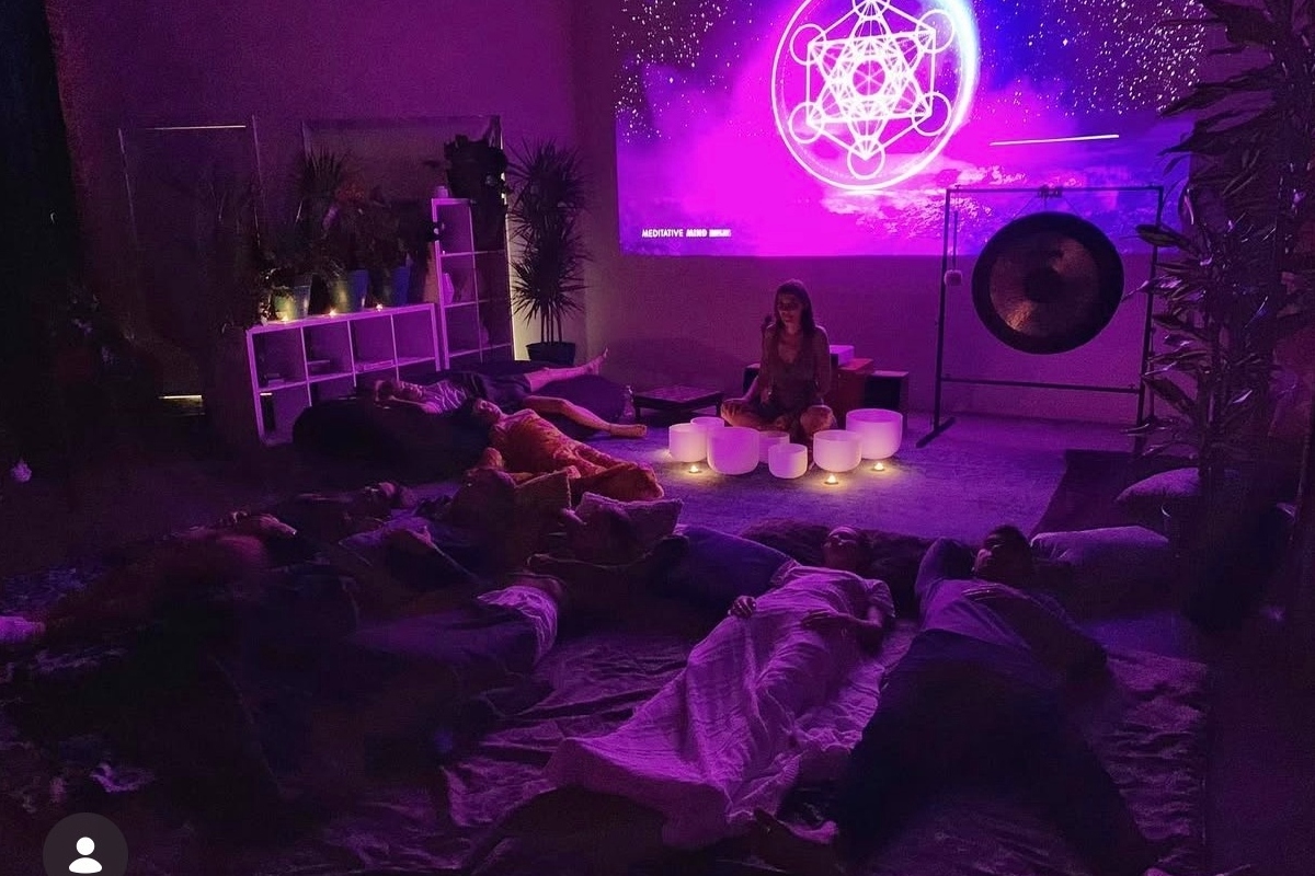 Group sound healing session with sacred geometry projection and crystal bowls