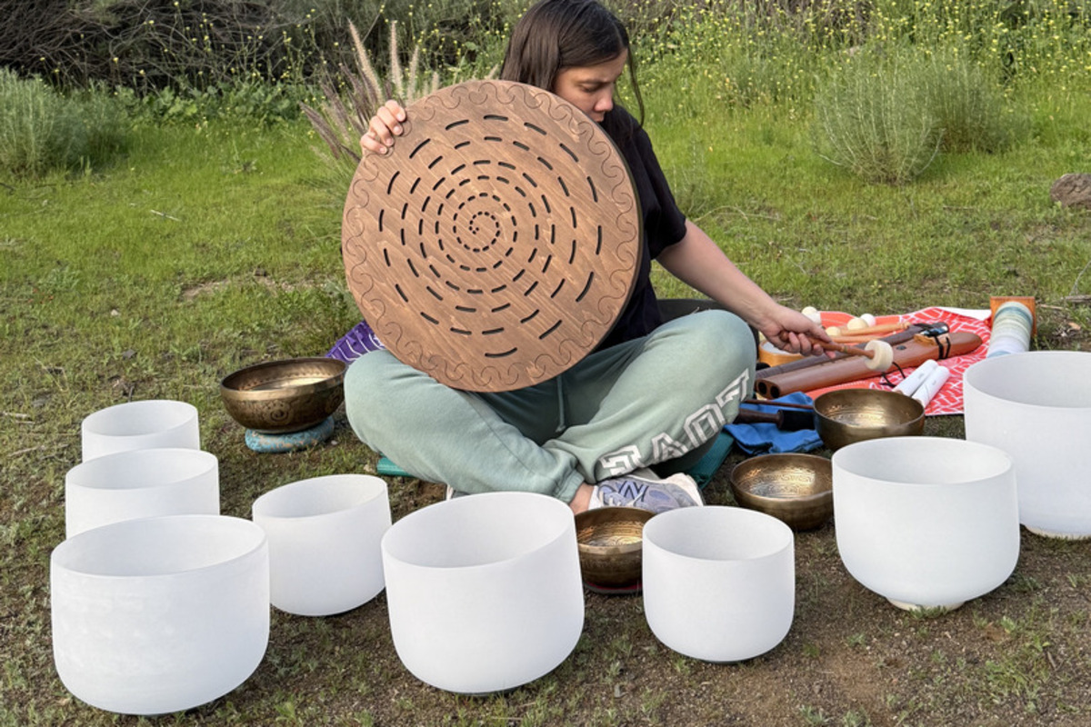 Julia with crystal bowls and shamanic drum outdoors in nature