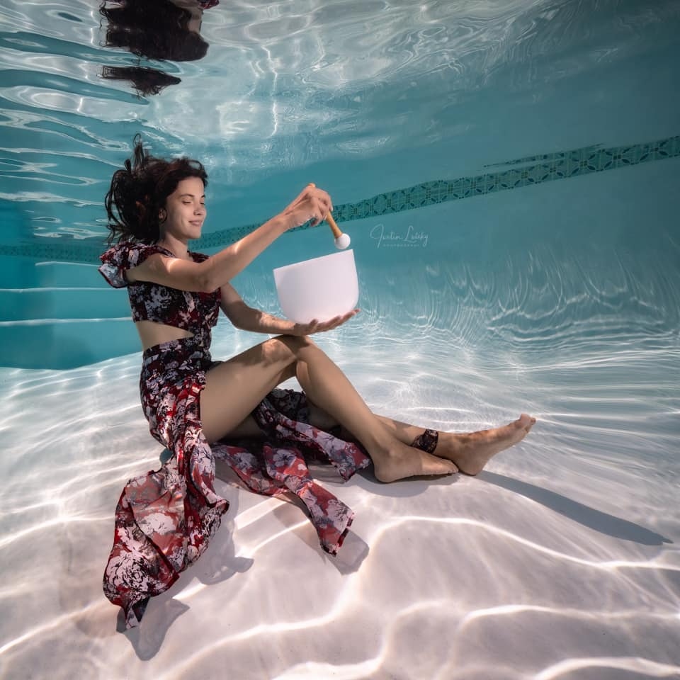 Julia Vorontsova playing a crystal singing bowl underwater