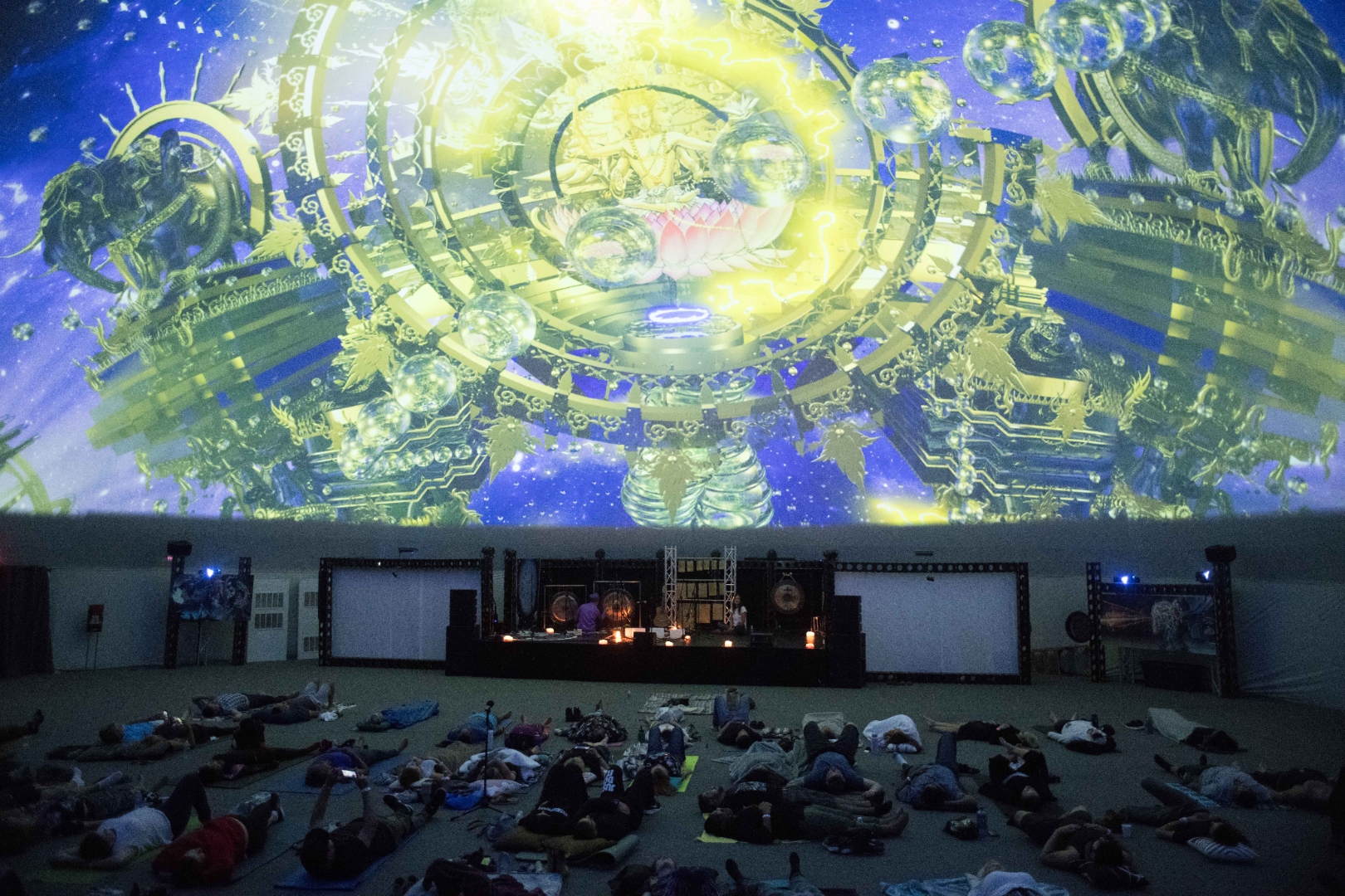 Large audience during an immersive sound healing event with fractal dome projections